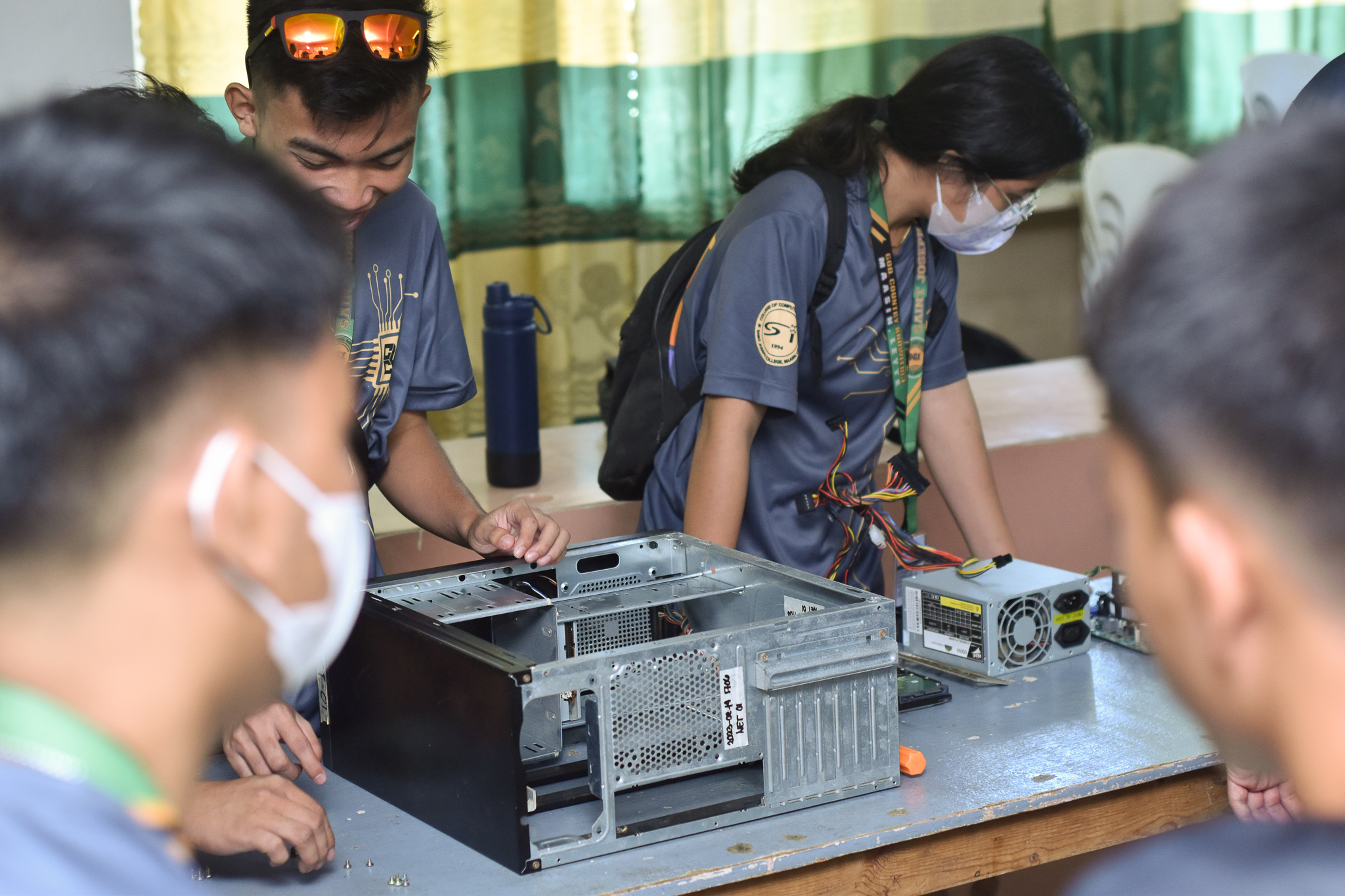 CCS students in a hands-on PC assembly session — peer tutoring program